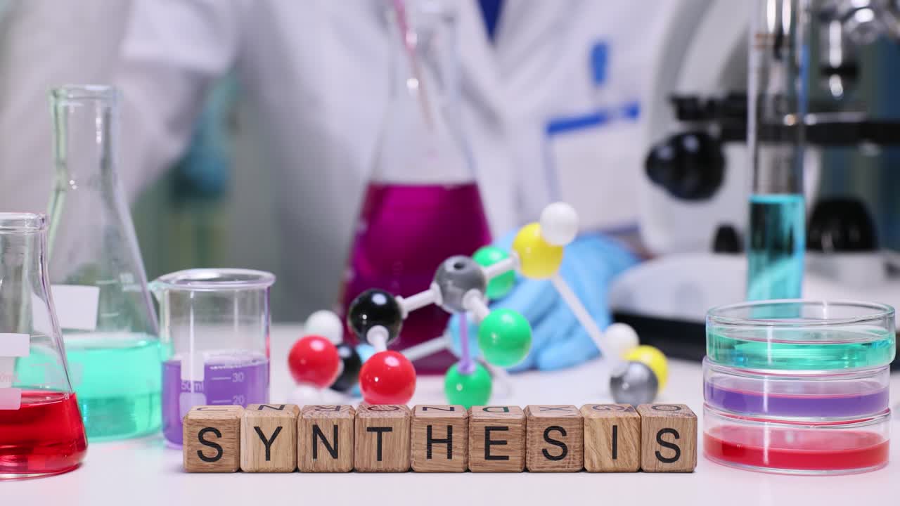 Wooden blocks spell synthesis as scientist mixes lab solutions