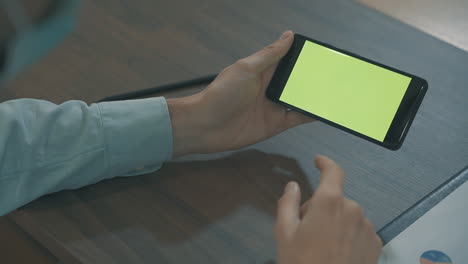 close up of hands using a green screen smartphone