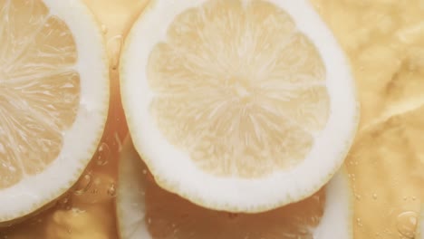 video de rebanadas de limón cayendo en el agua con espacio de copia en fondo amarillo