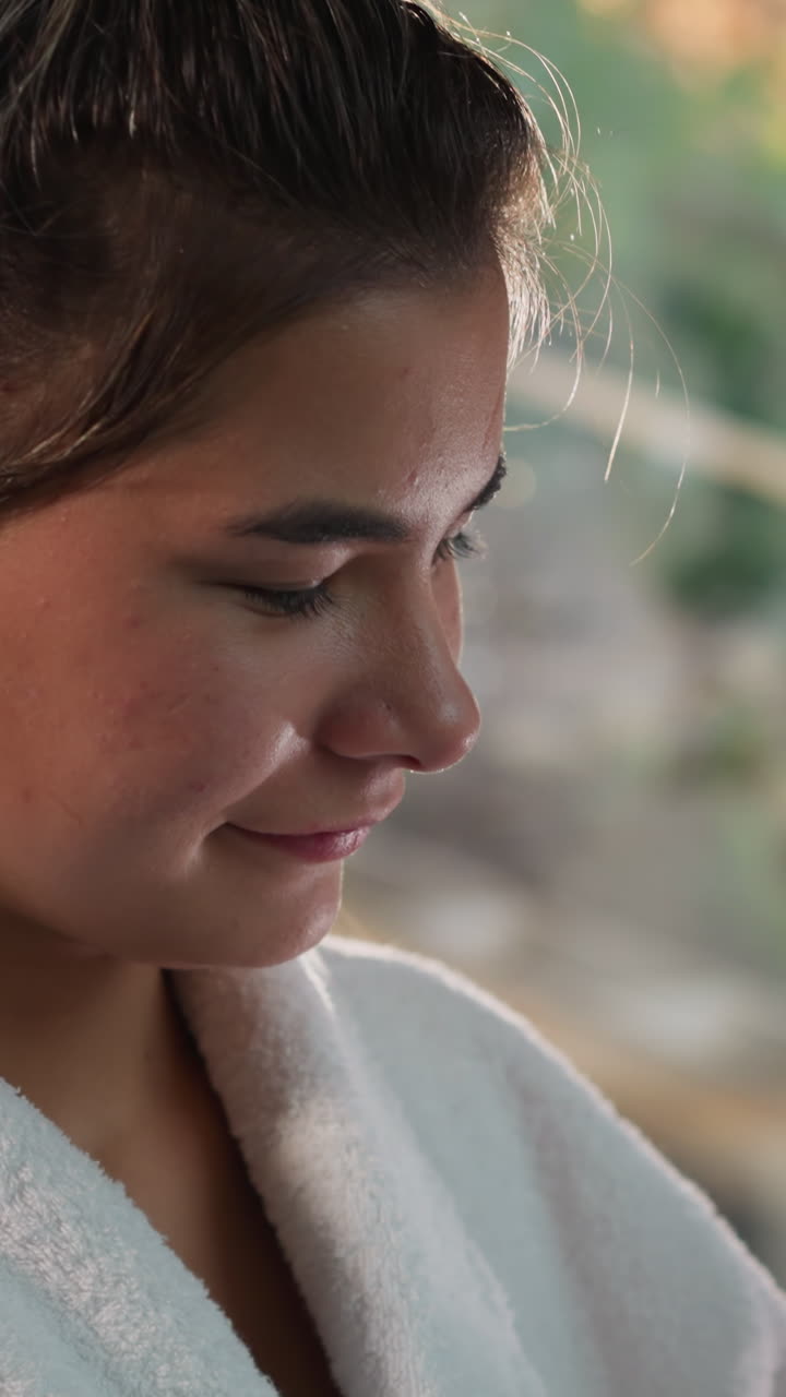 una mujer joven en bata de baño se acerca a un joven. una mujer enamorada muestra cuidado hacia el amante por la mañana. la pareja encuentra alegría en momentos simples juntos