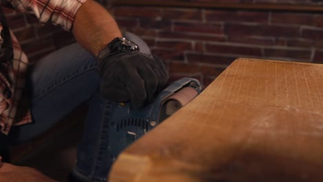 man sanding wood slab