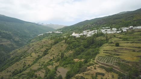 aerial ascending view of the valley of poqueira with the villages of bubion and capileira with sierra nevada behind