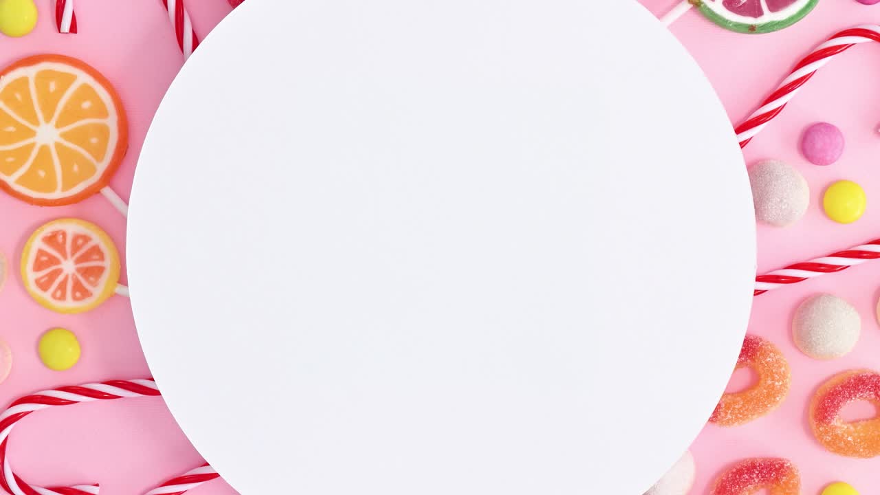 copia el espacio con caramelos y piruletas sobre un fondo rosa pastel.