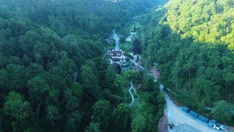 view of hunter's inn pub from the air while construction work is completed on new bridge with yard for diggers and trucks surrounded by dense forest trees