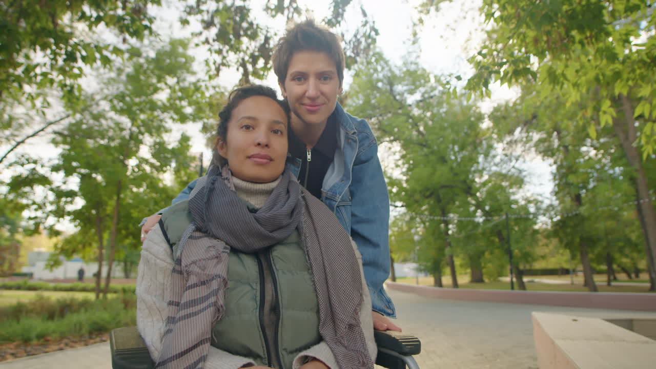 Two women in a park, one in a wheelchair