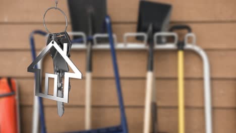 Animation-of-hanging-silver-house-keys-against-blurred-view-of-cleaning-equipment