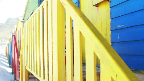 girl sitting near colorful beach hut