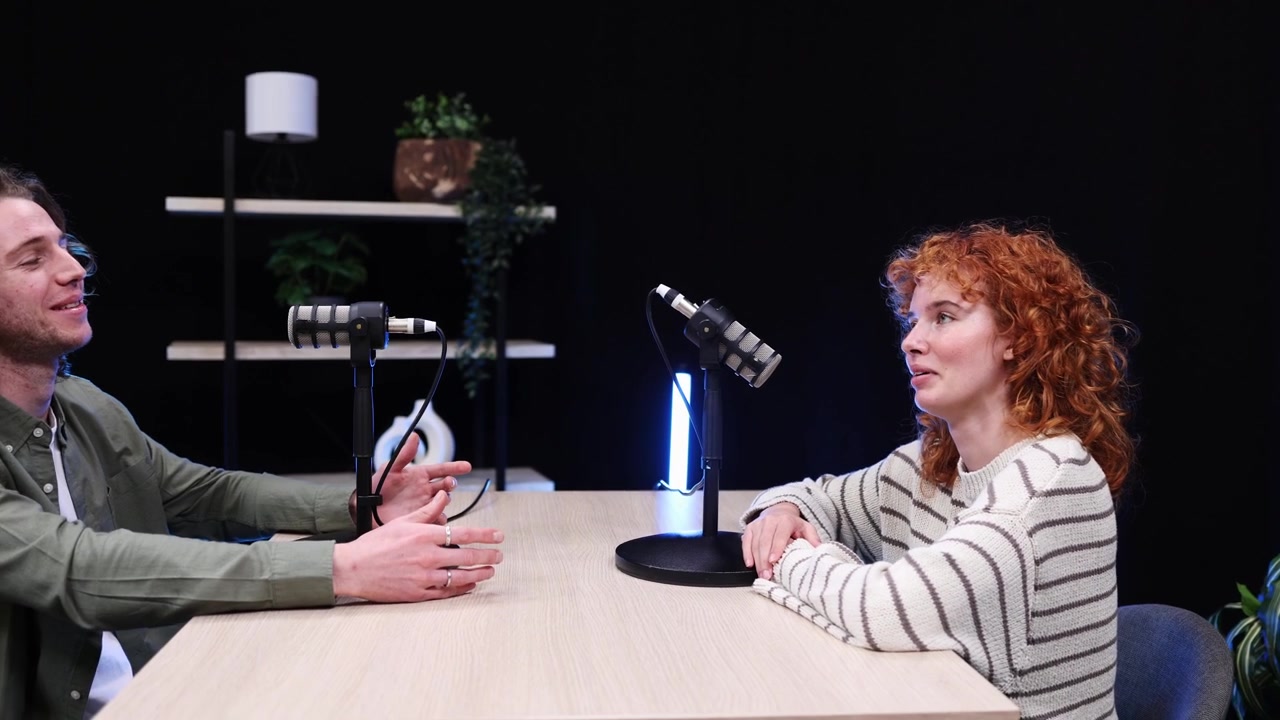 Uomo e donna che registrano un'intervista podcast in uno studio moderno