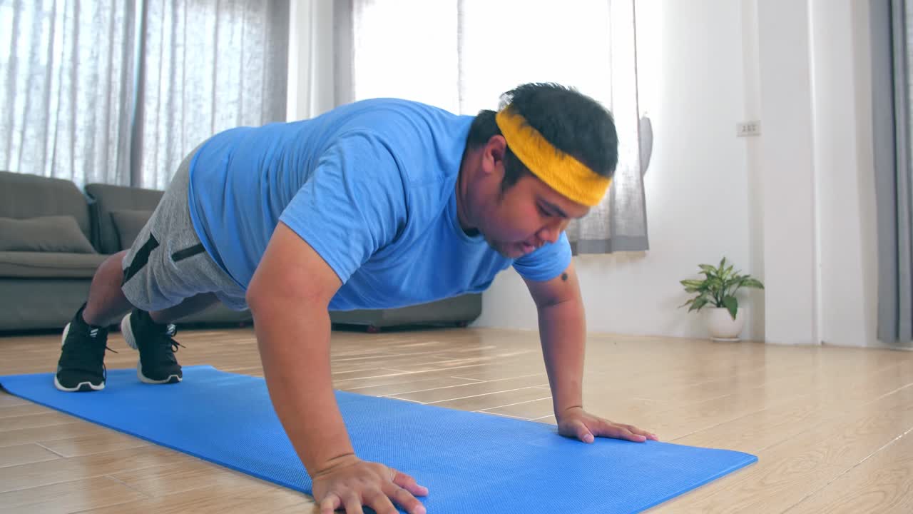 Overweight Male Struggling To Do Push Ups At Home
