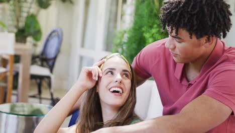 una feliz pareja biracial pasando tiempo en casa hablando y abrazándose
