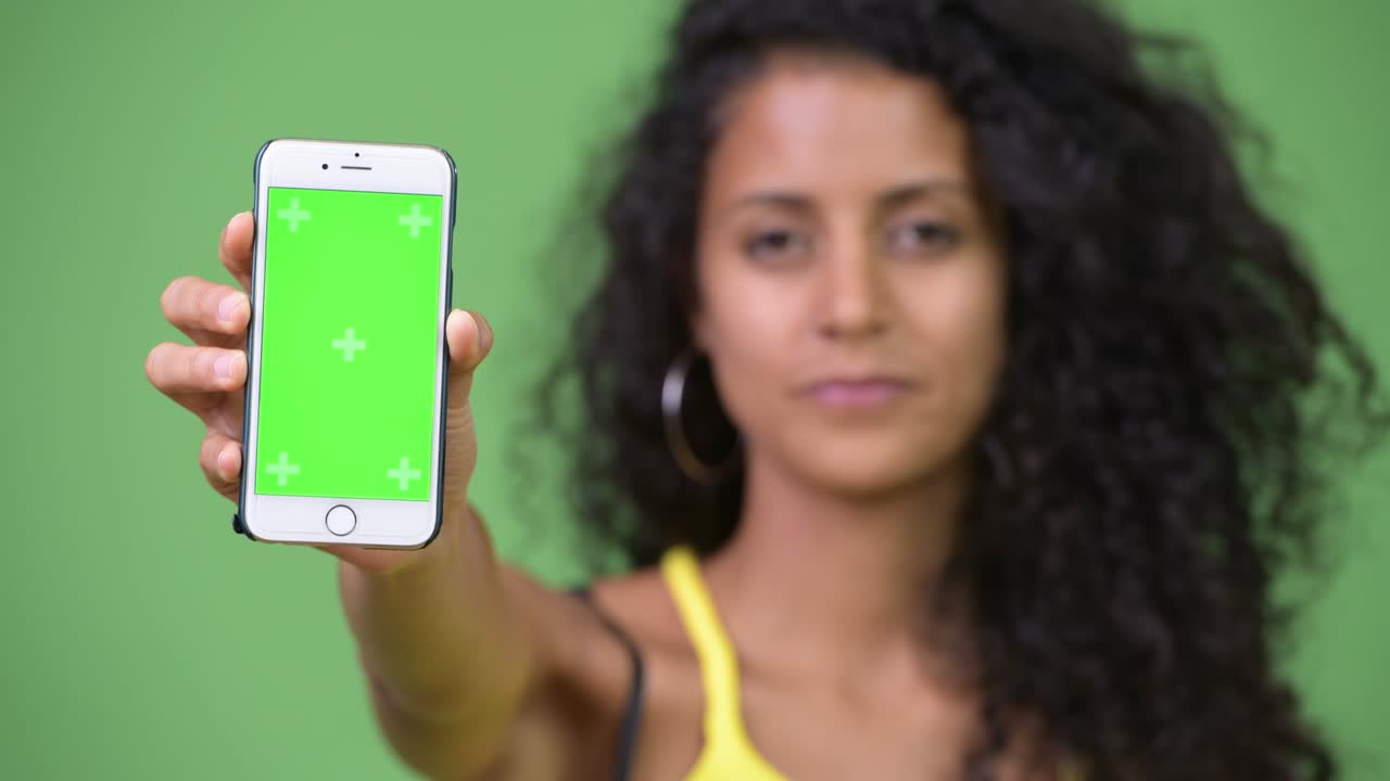 Young beautiful Hispanic woman showing phone