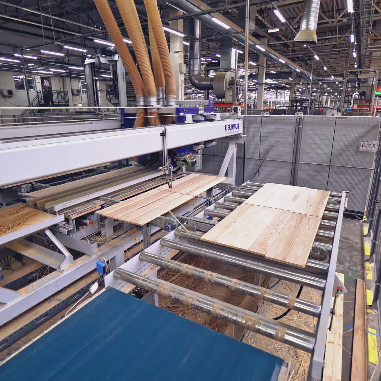 Modern automatic line is grinding the parquet boards with motion to the right and left and moving to another area of work at the plant for the production and sale of parquet.