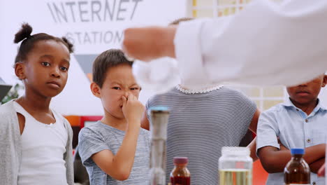 los niños ven el experimento con el quemador bunsen en el centro de ciencias.