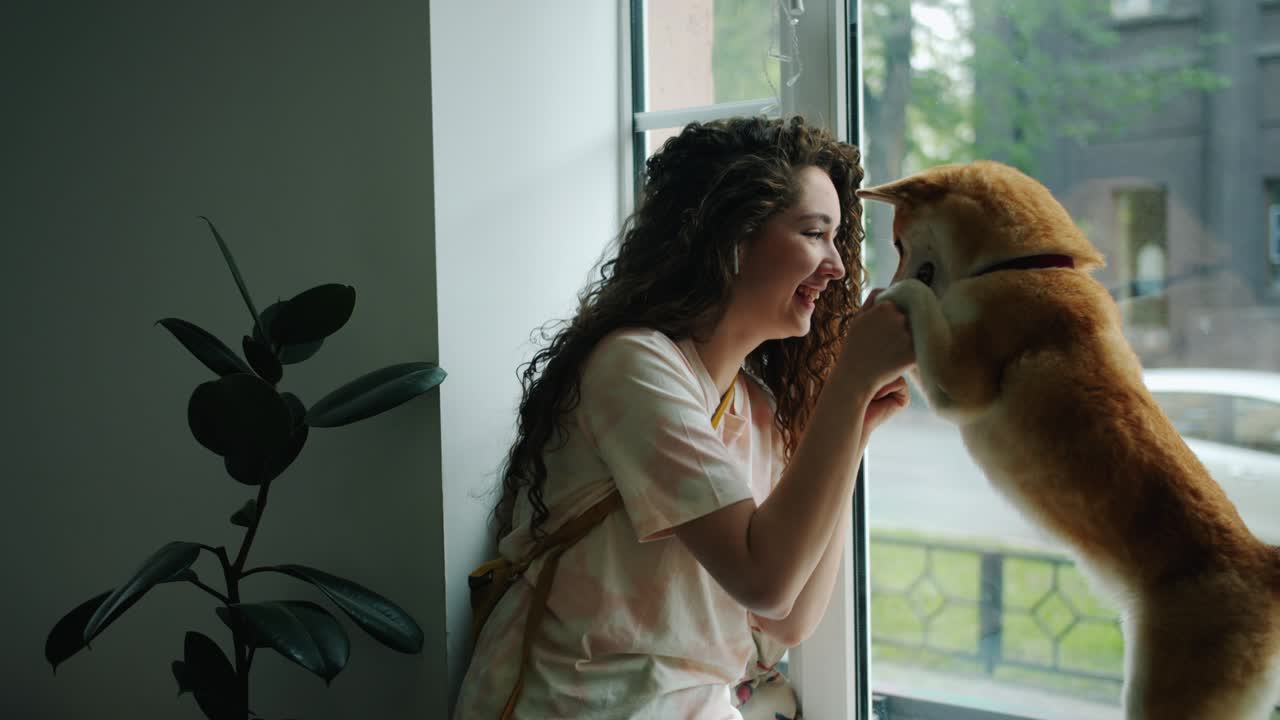 기쁜 소녀가 헤드폰을 통해 음악을 듣고 카페에서 개와 춤을 춘다