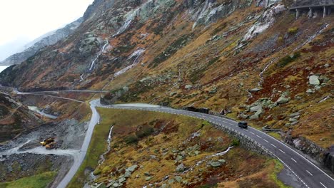 gray-camper-van-driving-Grimselpass-road-in-Switzerland-in-autumn