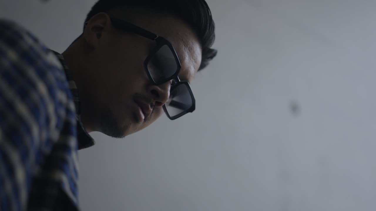 Asian man with sunglasses looking at the camera while walking