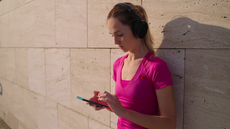 Woman using phone while exercising outdoors