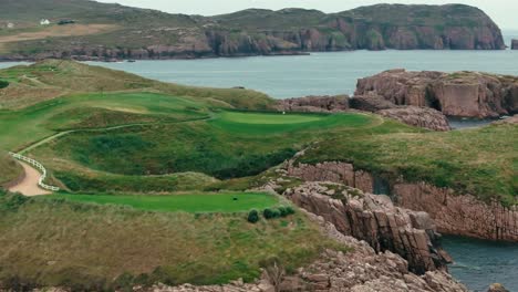 coastal cliffs surrounding ireland links golf course from above