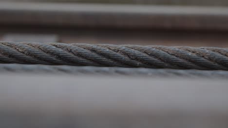 handheld close up shot of industrial braided iron cable getting retracted