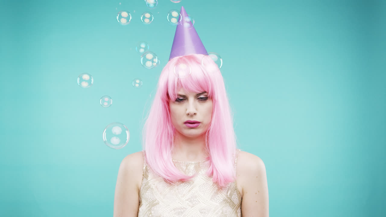 cara loca cabello rosa mujer bailando en la ducha de burbujas cámara lenta cabina de fotos fondo azul