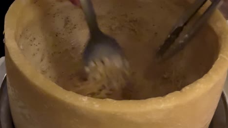 mezclar pasta en la rueda de queso en el restaurante italiano de cerca
