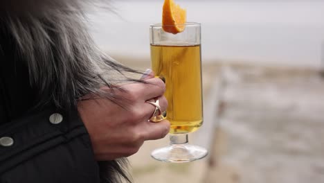 woman holding a warm drink by the lake