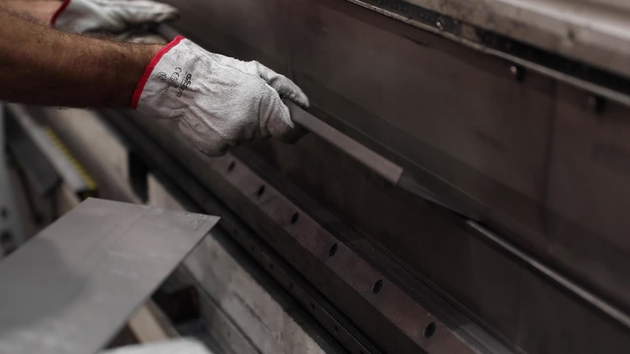 técnico que opera una máquina hidráulica de doblar en el trabajo