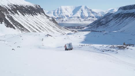 passenger winter mountain tracked vehicle leaving after transporting hikers, handheld