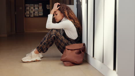 college, woman on floor in hallway