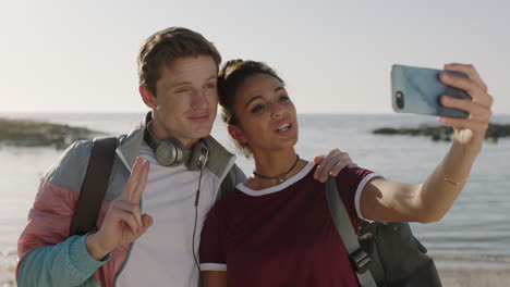 young couple taking selfie on sunny beach using phone smiling happy enjoying vacation