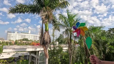 pinwheel rotates with wind against urban backdrop