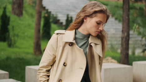 caucasian female student resting in the park and checking phone.