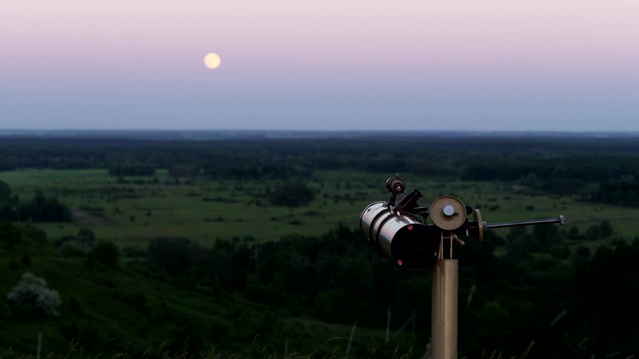 un telescopio profesional está dirigido a la luna al anochecer