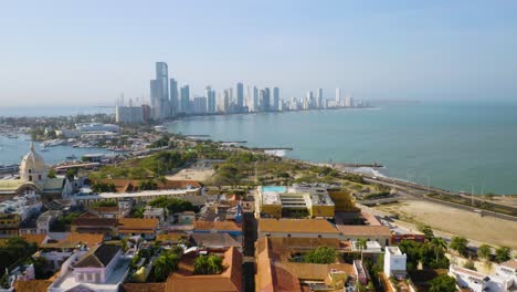 vista aérea de la ciudad vieja de cartagena con horizonte moderno, océano en segundo plano