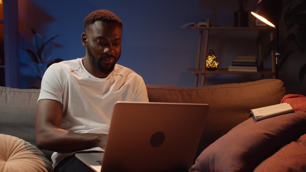 Man using laptop at home in the evening