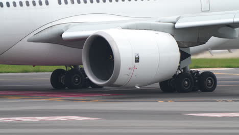 lisbon, portugal - april 7, 2025: detailed side view of a rolls-royce engine mounted on the wing of a commercial aircraft on the taxiway at lisbon airport. the aircraft's landing gear and fuselage are partially visible, highlighting the engine design and branding