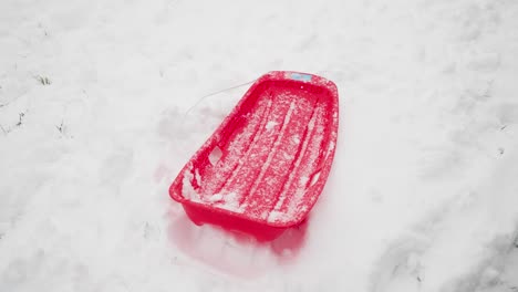 red sled covered in snow