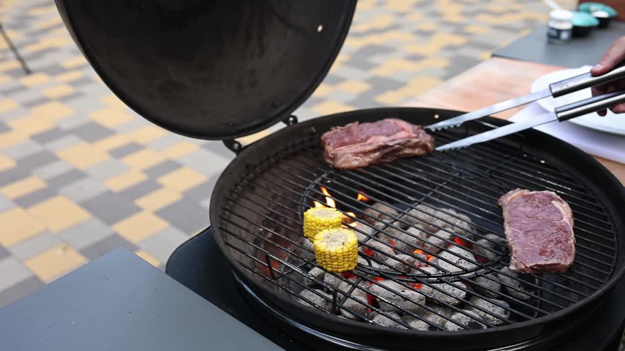 야외에서 스테이크와 옥수수 김