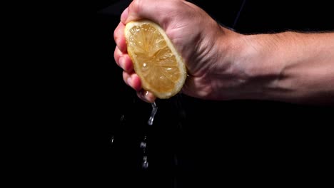 male hand squeezes juicy lemon to make lemonade
