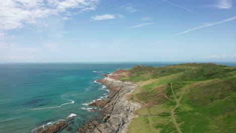 rising aerial shot of a coastal headland in north devon on a summer’s day