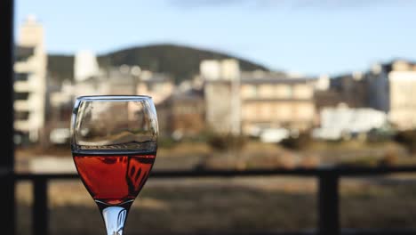 el vaso de vino se vacía lentamente contra un paisaje urbano.