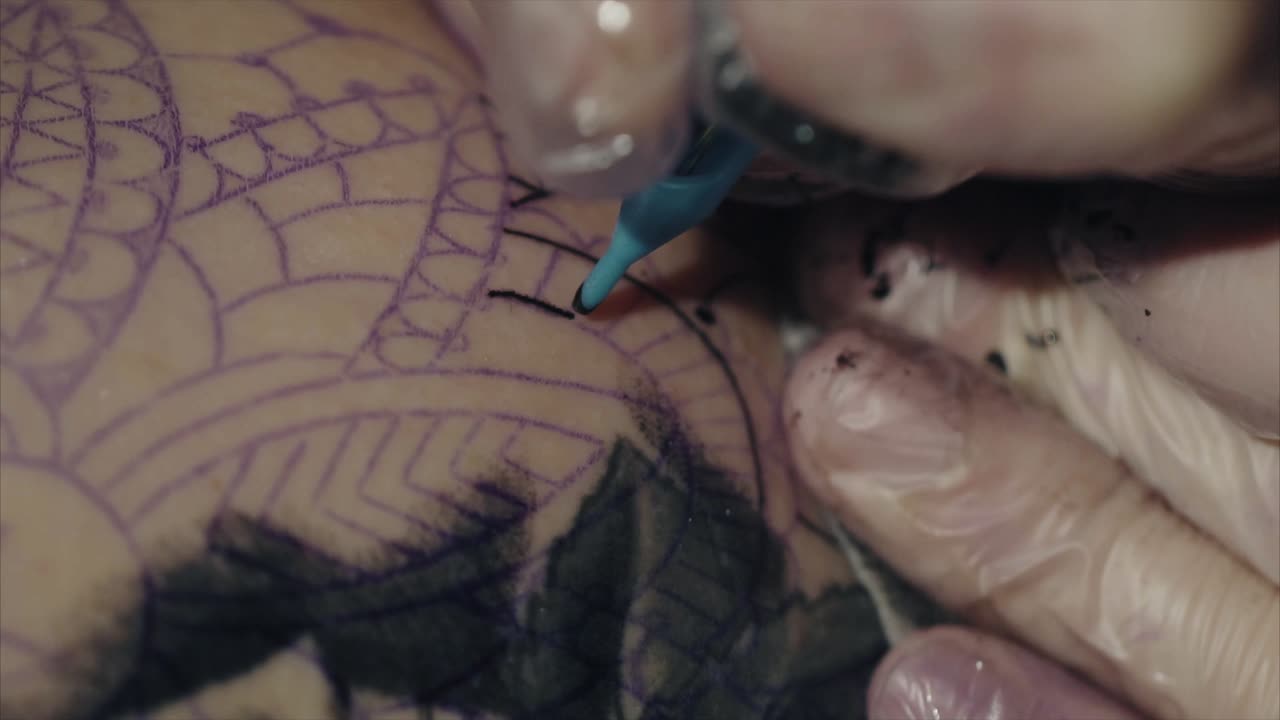 Tattoo artist inking a complex design on an arm