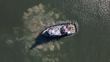 a top down view of a tugboat on a sunny day in the east rockaway inlet in queens, ny