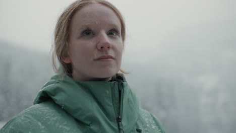 woman in a green jacket in snowy landscape