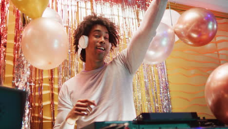 video of happy african american male dj playing music and talking in microphone at a nightclub