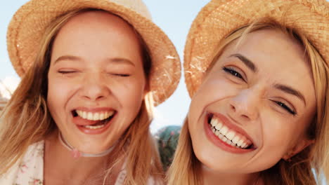 two happy women wearing straw hats