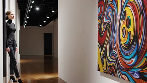 woman viewing abstract painting in art gallery