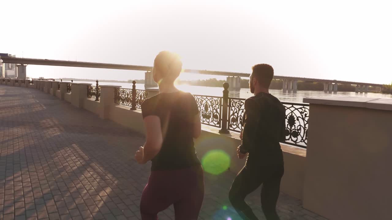 Coppia che corre all'alba lungo il fiume