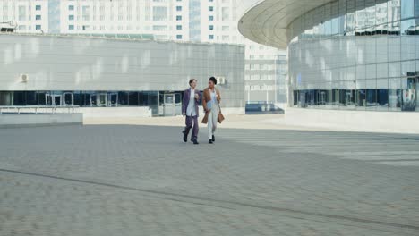 businesswomen walking and talking in a city plaza