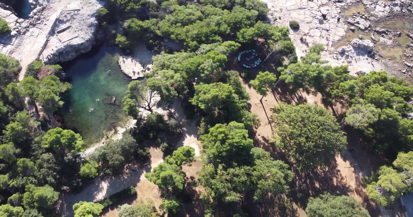 Vista aerea dell'isola di Lokrum, che mostra la costa rocciosa, il monastero e la laguna di acqua salata dove i turisti possono nuotare in una soleggiata giornata estiva di tranquillità; Lokrum, Dubrovnik, Croazia